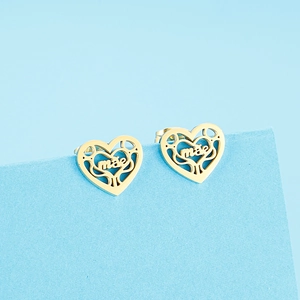 Gros plan de boucles d'oreilles cœur doré avec arbre de vie et gravure mã pour maman