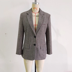Detail view of houndstooth blazer featuring notch lapels and flap pockets on mannequin