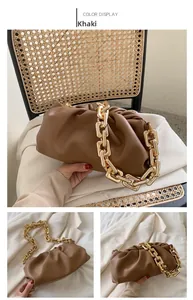 Detail of khaki pleated cloud bag with thick gold metal chain strap on textured seat