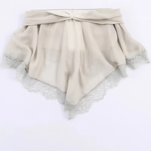 Élégante blouse en georgette beige avec dentelle présentée à plat sur fond blanc épuré