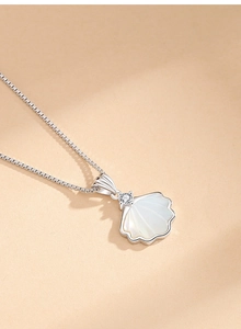 Macro detail of a shell pendant with a zircon stone and a silver box chain