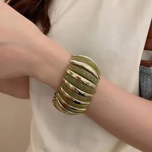Wide stretch bracelet with alternating gold metal segments and translucent green resin links