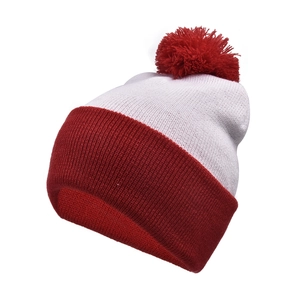 Detailed view of red and white knitted Christmas hat with a soft pompom on top