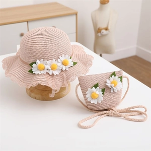 Detail of pink woven straw sun hat and matching crossbody bag with daisy floral accents