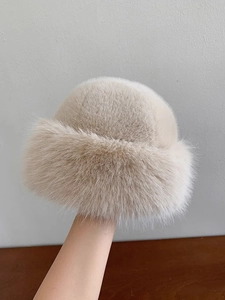 Close-up of plush faux fur texture on a warm cream-colored bucket hat for winter
