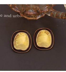 Detailed view of vintage gold hammered texture earrings with elegant dark enamel border