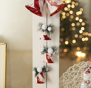 Detail of red Christmas bell ornament with snow patterns and pine needle decor