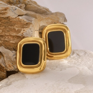Macro shot of vintage rectangular black resin earrings with golden stainless steel frames