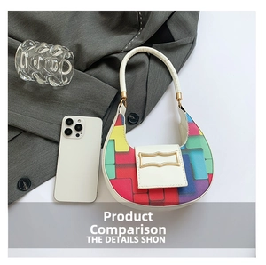 Detail view of mini crescent handbag with colorful patterns and a smartphone for scale