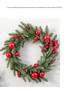 Close-up of Christmas wreath with snowy pine needles, red berries and plaid bow