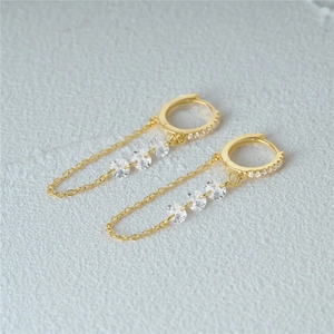 Detailed macro view of S925 silver gold-plated long earrings with cubic zirconia stones