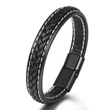 Detail of black braided leather bracelet featuring white stitching and a matte metal clasp
