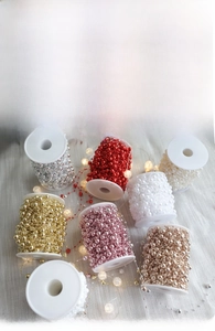 Close-up of assorted colored beads on spool for Christmas tree decoration and DIY