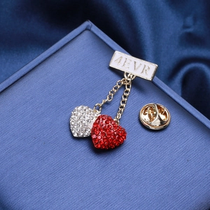 Detail of golden heart brooch with 4EVR lettering and sparkling red and white rhinestones