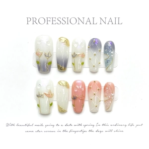 Detailed view of handmade press-on nails with tulip art, pearls and gold foil accents