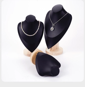 Detail of matte black female mannequin bust for necklaces with solid wood round base