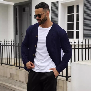 Detail of navy blue knit cardigan with textured buttons and premium jacquard weave