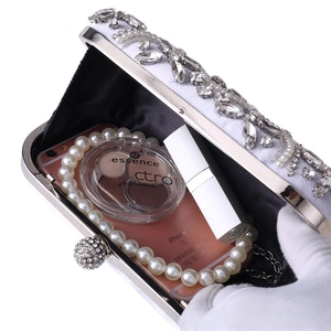Detail showing white satin evening bag interior capacity for phone and makeup