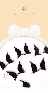 Detail of black bat wing hair clips for Halloween costume featuring matte felt texture