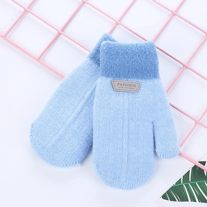 Close-up of blue winter knit mittens with plush cuffs and a fashion label design