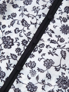 Gros plan du tissu de chemise à fleurs avec boutons recouverts et texture tissée