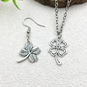 Antique silver four-leaf clover jewelry set featuring a necklace and matching earrings