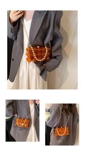 Detail view of orange acrylic beaded bag with golden chain and pearl-style handle