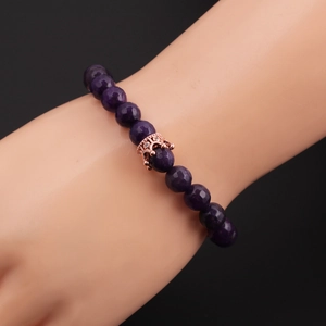 Detail of purple 8mm faceted stone beads and rose gold crown charm on men's bracelet
