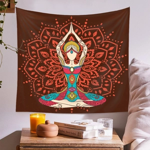 Bohemian mandala tapestry with yoga figure in warm brown and teal tones on a wall