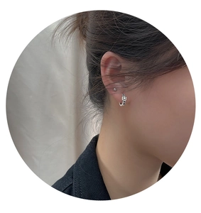 Macro detail of vintage silver-plated twisted hoop earring with black smiley face design