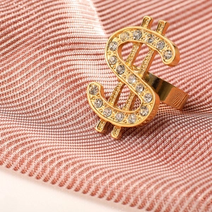 Iced out gold dollar sign ring with sparkling crystals on premium textured fabric