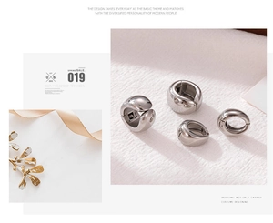 Minimalist silver geometric metal ear cuffs shown with dry flowers and beige ribbons