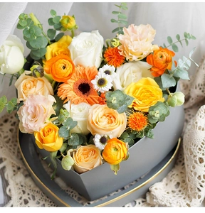 Close-up of heart-shaped floral gift box with colorful roses and green eucalyptus