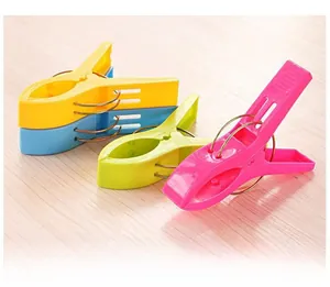 Detail of four colorful heavy-duty plastic windproof laundry pegs with strong metal springs