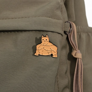 Detailansicht der kreativen Emaille-Anstecknadel mit Muskelkatze auf grünem Canvas-Stoff