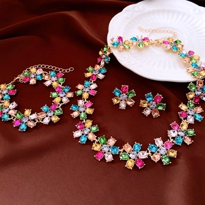Exquisite flower jewelry set with colorful crystals and gold metal on silk background