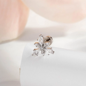 Elegant silver snowflake stud earrings with micro-pave cubic zirconia on a white stand