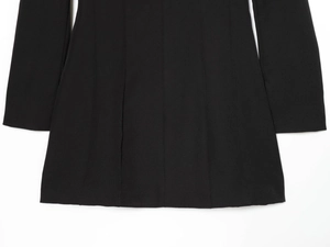 Gros plan sur l'ourlet de la robe moulante noire montrant la texture du tricot