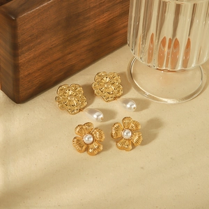 Elegant 18k gold plated stainless steel floral earrings with pearl drops on soft fabric