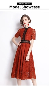 Detail of dark red lace dress featuring intricate black lace trim and high-neck design