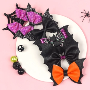 Close-up of Halloween hair clips with bat wings and spider web patterns on a white plate