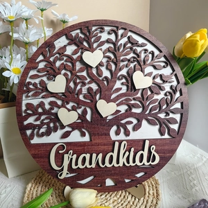 Detail view of round wooden plaque with Tree of Life design and Grandkids heart charms