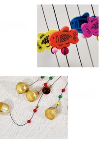 Detailed view of colorful wooden fish pendants and golden metal bells for home hanging decor