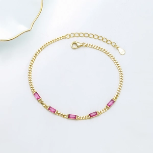 Macro shot of S925 sterling silver gold bracelet with pink square-cut gemstones