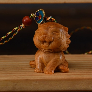 Detailansicht eines handgeschnitzten Thuja-Tiger-Anhängers mit buntem Seil und Emaille-Perlen