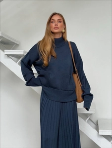 Navy knit set featuring oversized turtleneck sweater and matching pleated midi skirt
