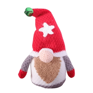Handmade knitted Christmas gnome plush doll with star decoration and bell on white background