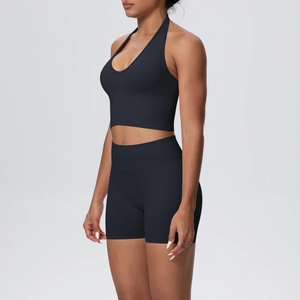Detail of seamless black halter yoga bra and high-waisted shorts set on model