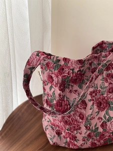 Gros plan sur le tissu jacquard rose rouge et l'étiquette simple wish du sac à épaule