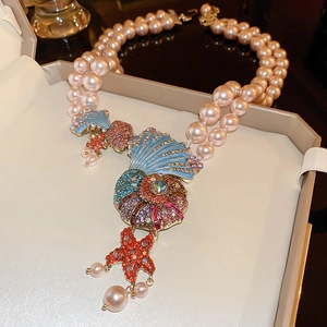 Detail of double-layer pink pearl necklace with shell pendant and starfish enamel